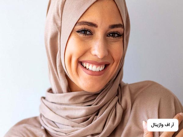 صورت خانمي در تصوير قابل مشاهده است که در حال لبخند زدن مي باشد. خانم حجاب دارد و شال به سر کرده است.