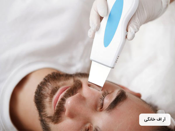 آقايي در حال ترميم پوست صورت خود به روش آر اف خانگي مي باشد. لباس اقا سفيد است.
