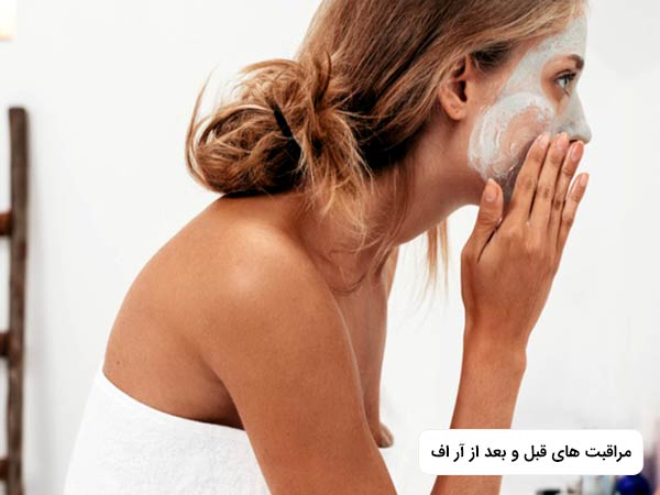 خانمي در حال ماليدن کرم به پوست صورت خود مي باشد. خانم حوله بر تن کرده است.