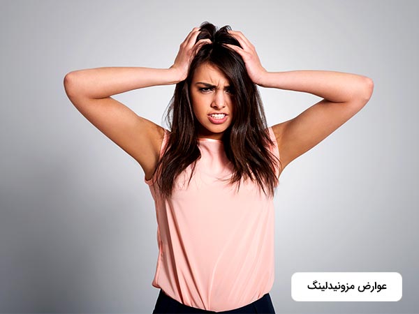 در تصوير خانمي از عوارض جانبي جوانسازي به روش مزونيدلينگ رنج مي برد. او با دست هاي خود سر خود را گرفته است.