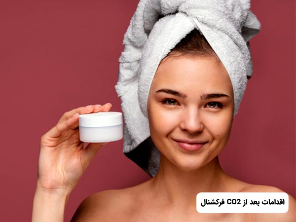 خانم در حال لبخند زدن مي باشد. او جوان است و در دست خود يک کرم دارد. خانم می خواهد دمراقبت های بعد از زیباسازی به روش CO2 فرکشنال را انجام دهد.