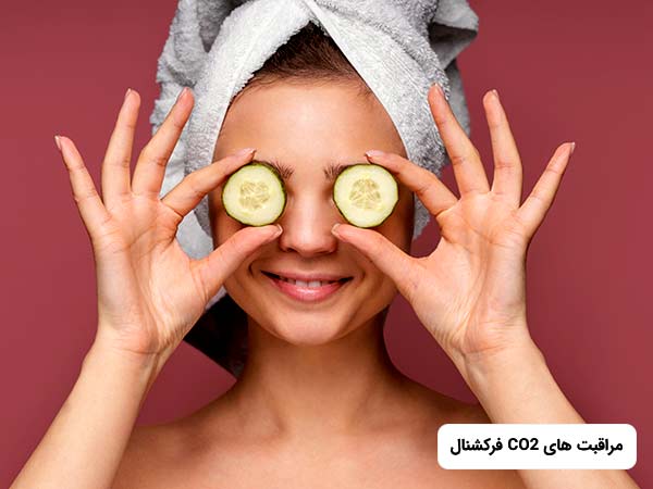 خانم جوانی دور سر خود حوله پيچيده و دو قطعه خيار روبروي چشمان خود گذاشته است.او در حال لبخند زدن مي باشد.