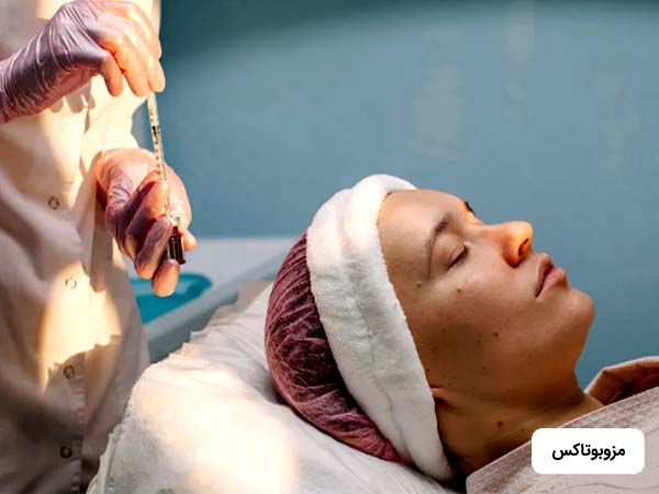 خانم روي تخت دراز کشيده و چشمان خود را بسته است. پزشک در حال آماده سازي براي انجام مزوبوتاکي روي صورت خانم مي باشد.