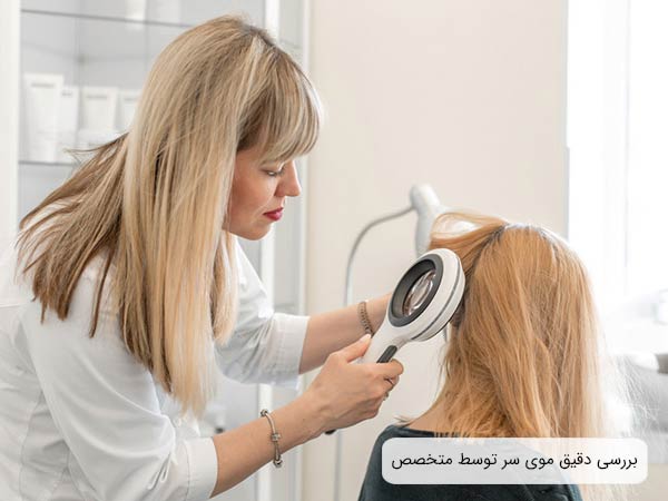 پزشک متخصص با دقت موی سر بيمار را بررسی می نمايد.
