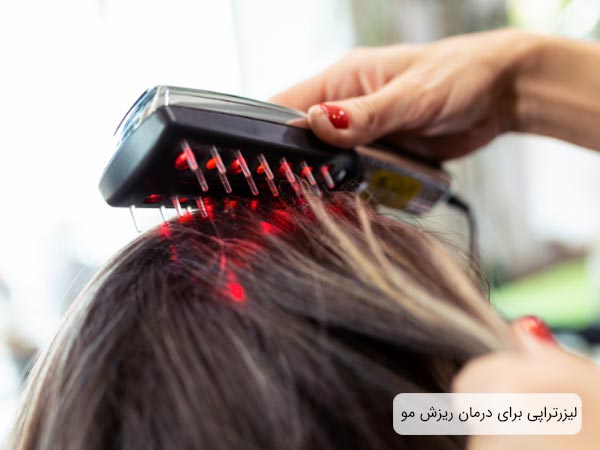 استفاده از ليزر توسط اپراتور بر سر يک خانم براي درمان ريزش مو