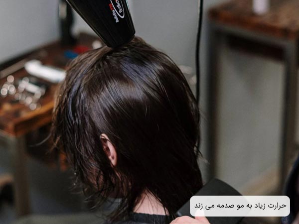 استفاده از سشوار بر روی موی سر يک خانم توسط آرايشگر.