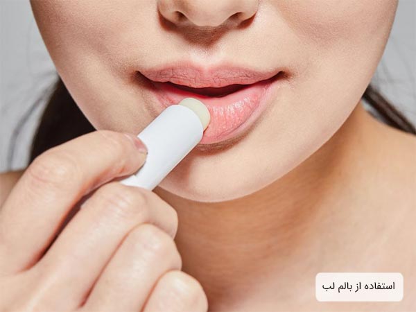 تزريق ژل لب توسط پزشک مجرب به لب های يک خانم با پس زمينه آبی روشن.