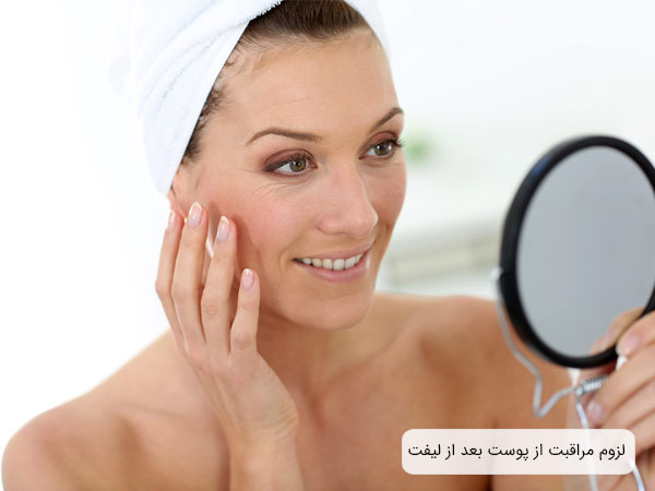يک خانم که در آينه به پوست صورت خود نگاه می کند.
