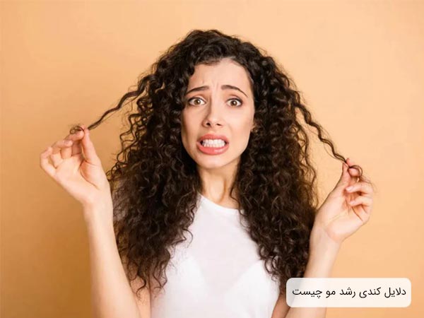 يک خانم با مو های فر و بلند با حالت چهره عصبانی و پس زمينه کرمی رنگ.