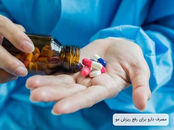 يک خانم که قرص هاي مختلف مخصوص ريزش مو را دارد روي دستان خود ميريزد