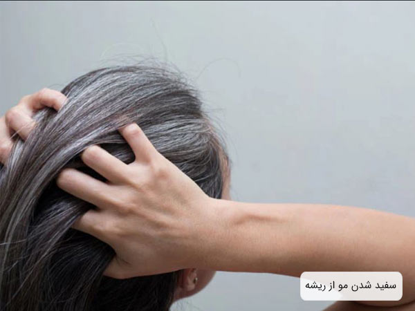 يک خانم با مو های سفيد که دست هاي خود را بالای سرش گذاشته است.
