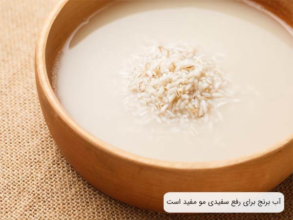 يک کاسه قهوه ای رنگ چوبی حاوی برنج و آب برنج روی يک سطح حصيری شکل.