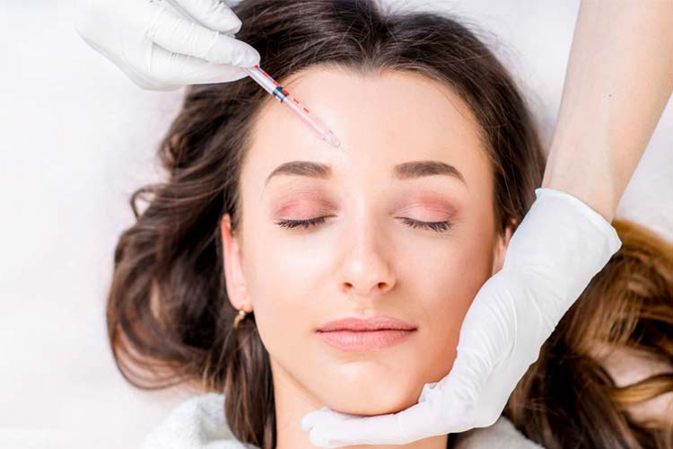 مزوتراپی ابرو های يک خانم جوان توسط پزشک با پس زمينه سفيد.