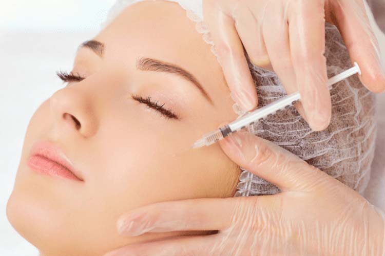 انجام مزوتراپی زیر چشم روی صورت یک خانم توسط پزشک با پس زمینه سفید.