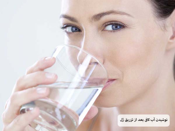 یک خانم در حال نوشیدن یک لیوان آب است.