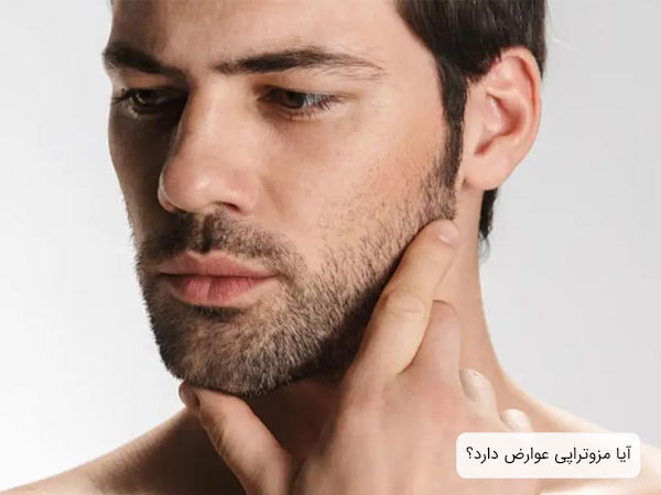 يک مرد جوان که با دست در حال بررسی ريش های خود است در پس زمينه سفيد.