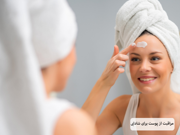خانمی در حال استفاده از نوعی کرم جوانساز روی پوست صورت خود است.