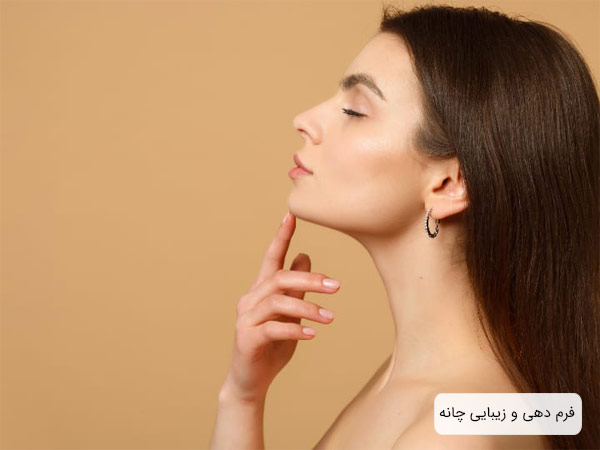 صورت يک خانم جوان از نيم رخ که انگشت اشاره خود را روي چانه اش گذاشته با چانه اي زيبا و خوش فرم در پس زمينه کرمی رنگ.