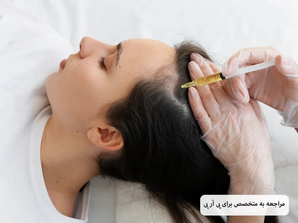 پزشک در حال تزریق سرنگ محتوی پی آر پی به سر یک خانم زیباجوی جوان.