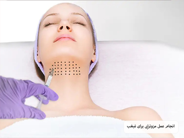 چند نقطه سیاه روی غبغب یک خانم زیبا جوی جوان ترسیم شده اند که نشان دهنده محل تزریق کوکتل مزوتراپی است که در حال انجام توسط پزشک می‌باشد.