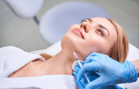 انجام مزوتراپی روی قسمت غبغب یک خانم زیباجوی جوان در کیلینیک تخصصی توسط پزشک.