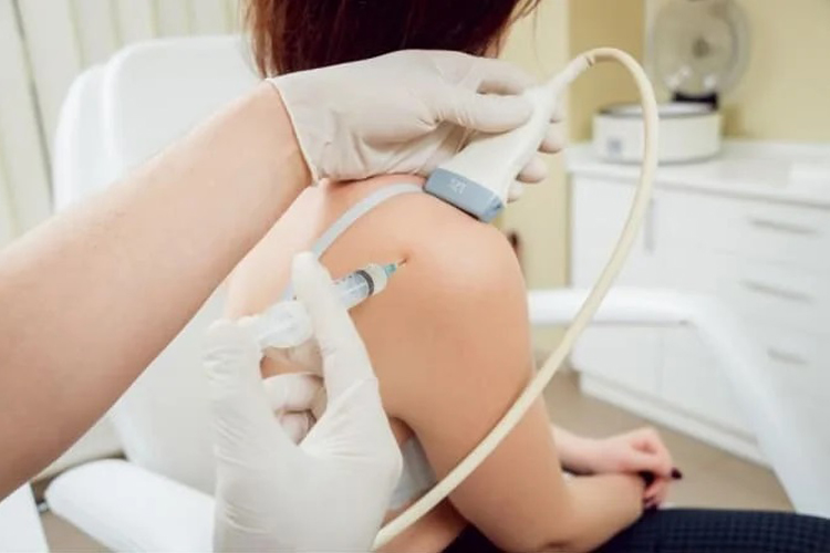 تزریق پی آر پی توسط متخصص به شانه یک خانم در کیلینیک.