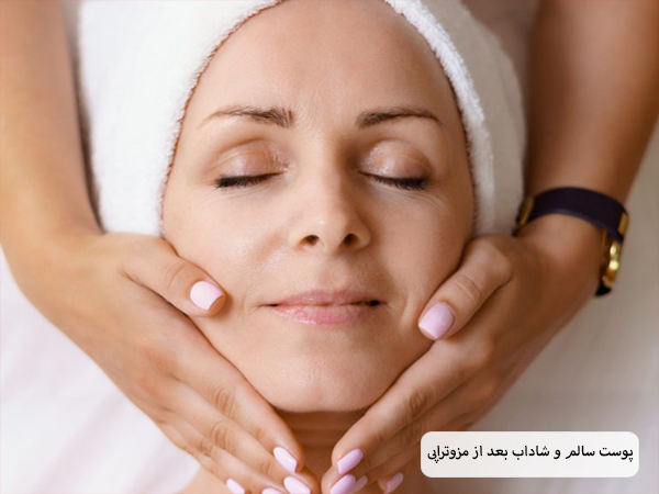 خانمی در حال ماساژ دادن پوست صورت یک خانم دیگ است.