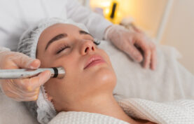 پزشکی در حال انجام مزوتراپی روی صورت یک خانم جوان در کیلینک تخصصی.